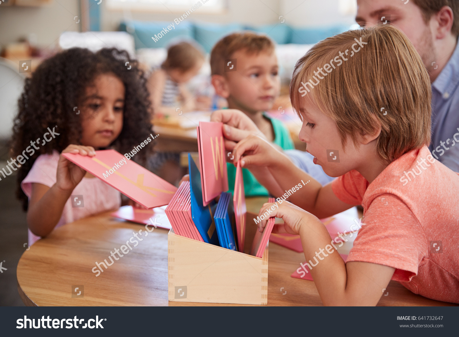 Teacher And Pupils Working With Letters In Montessori School #641732647