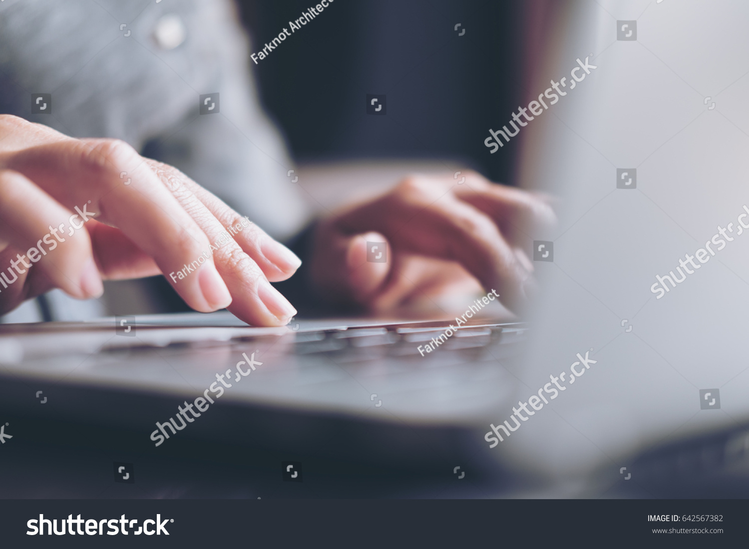 Closeup image of a business woman's hands working and typing on laptop keyboard on glass table #642567382