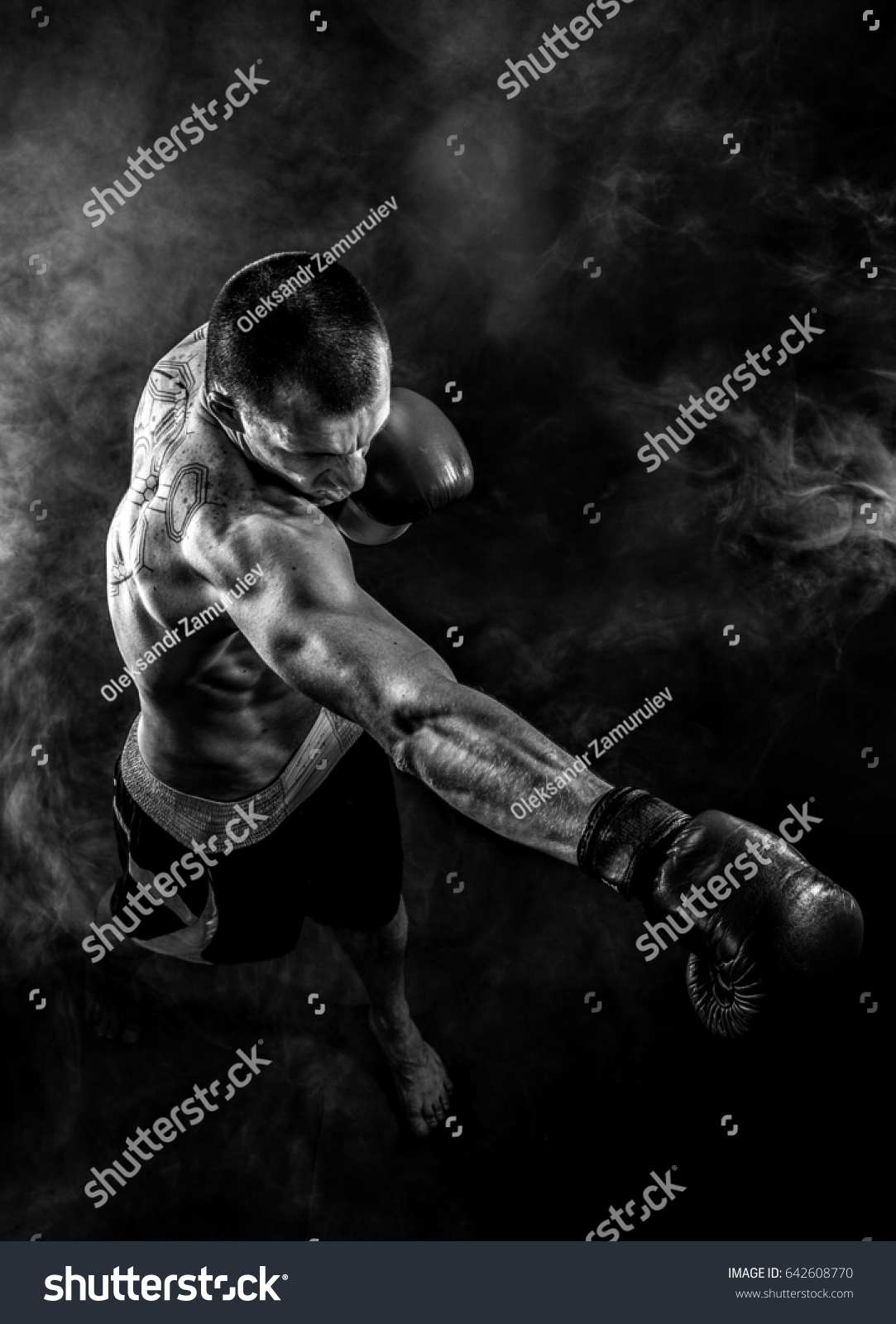 Muscular kickbox or muay thai fighter punching in smoke. #642608770