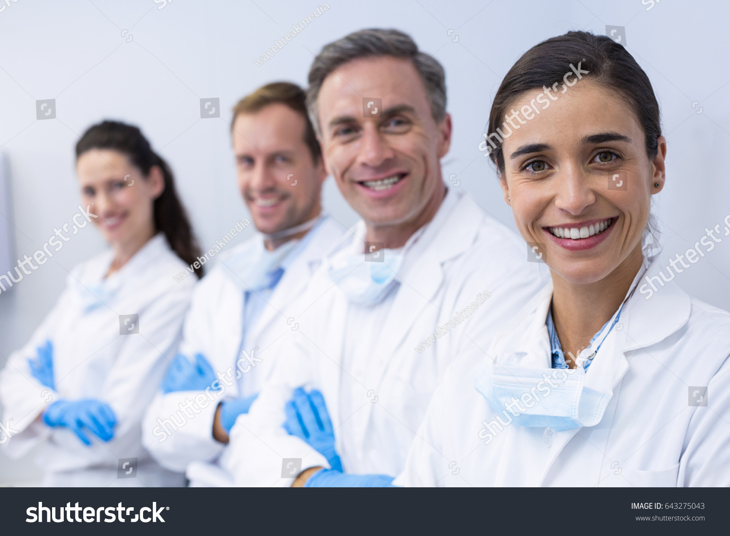 Portrait of smiling dentists standing with arms crossed in dental clinic #643275043