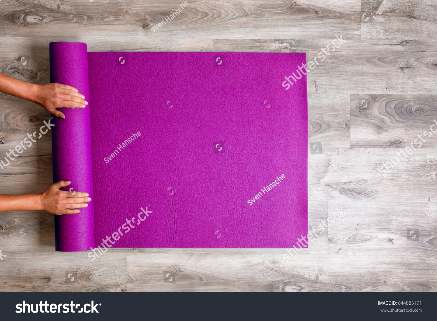 Woman rolling her Yoga mat after a workout - top view #644885191