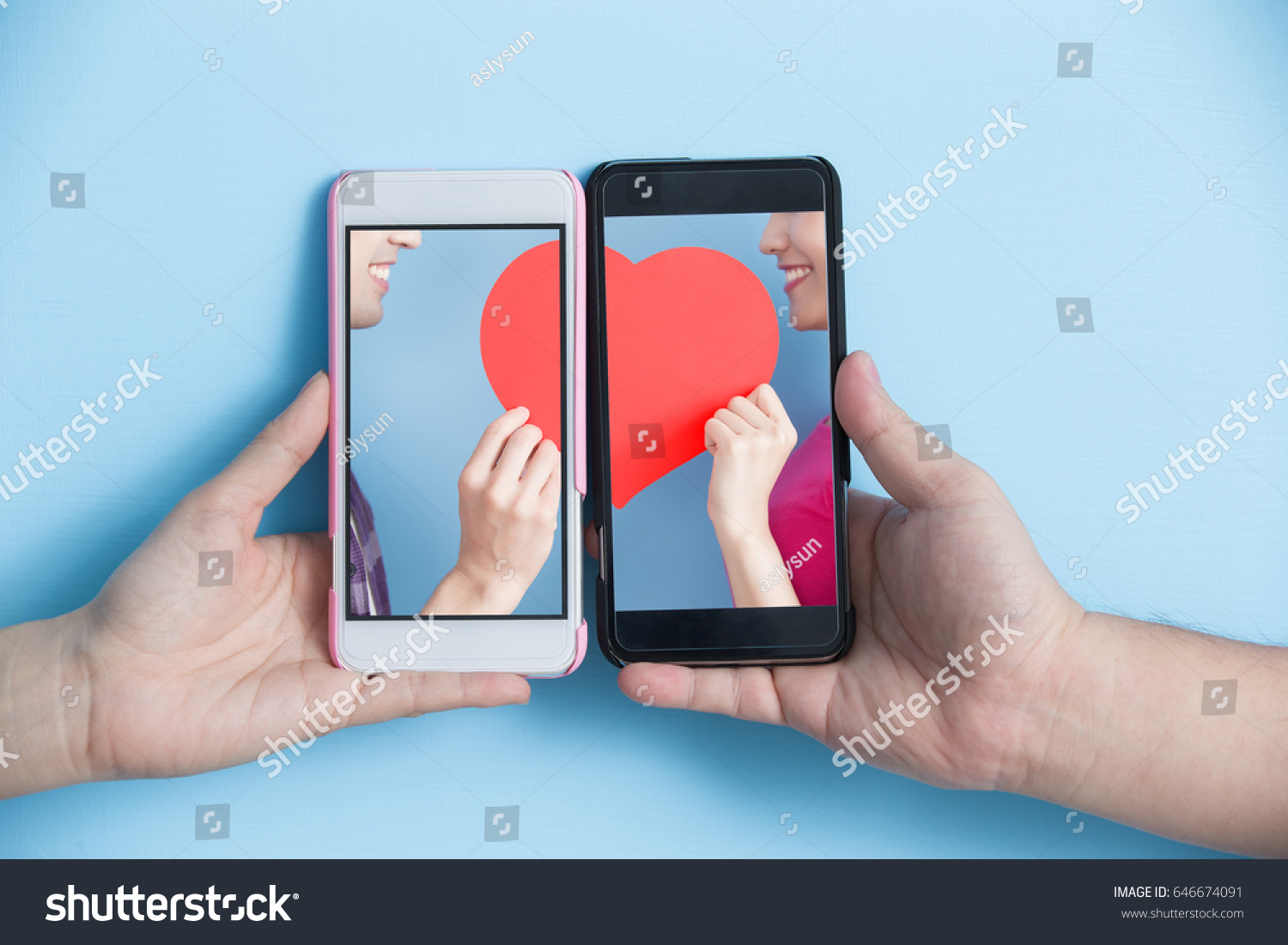 hand take smart phone with young couple take heart in screen on blue background #646674091