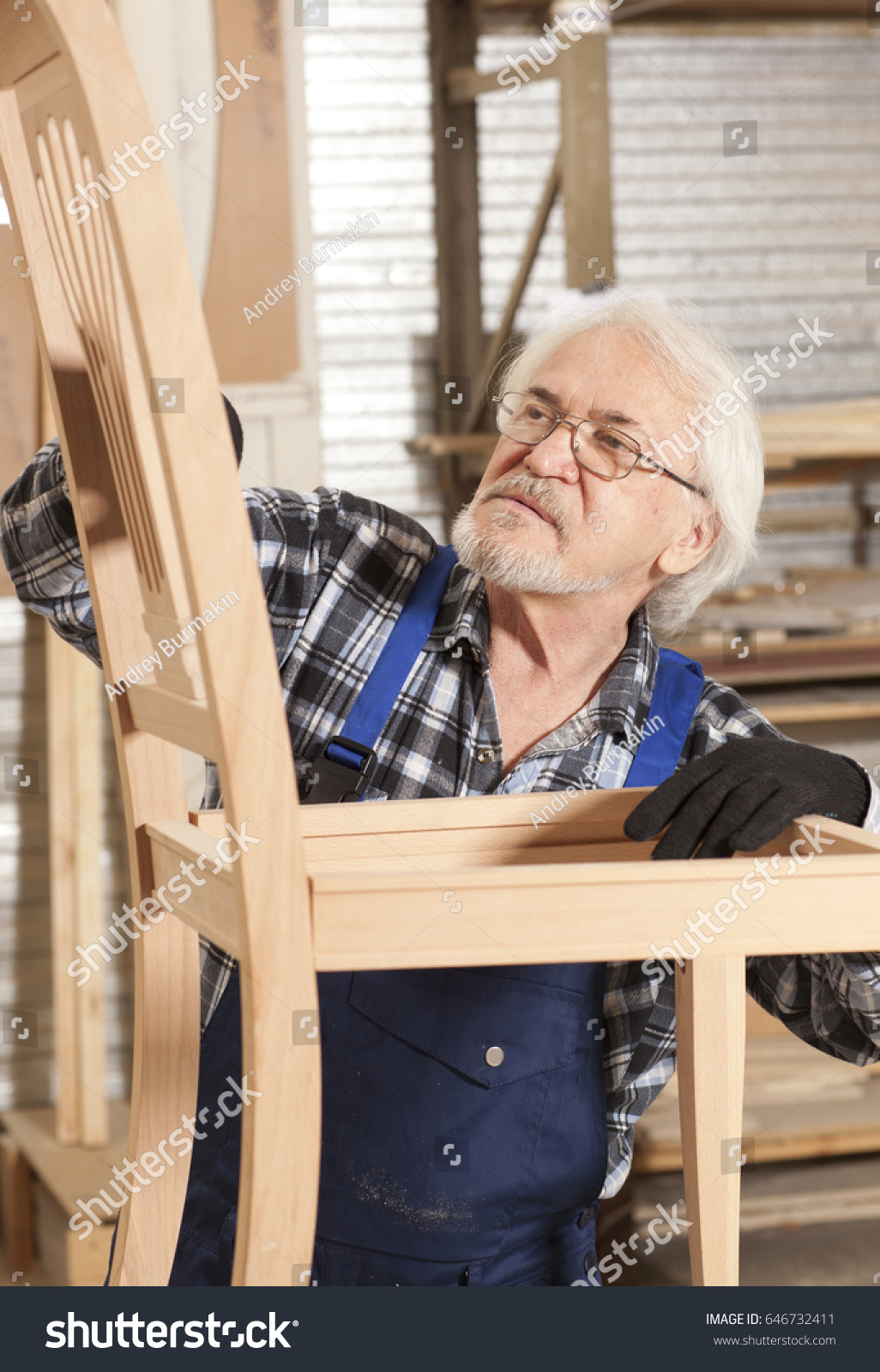 Senior carpenter working in furniture factory #646732411