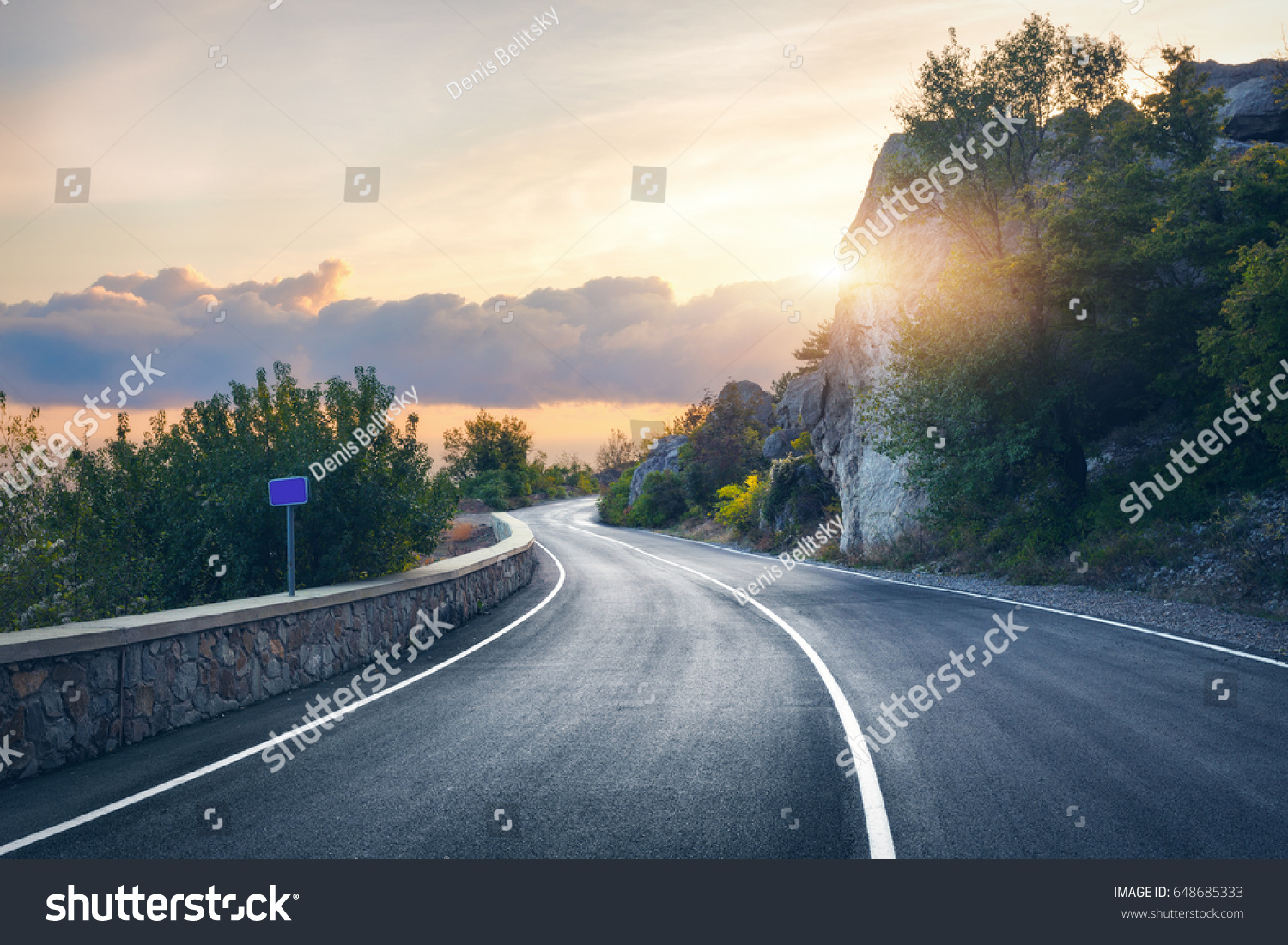 Mountain road. Landscape with rocks, sunny sky with clouds and beautiful asphalt road in the evening in summer. Vintage toning. Travel background. Highway in mountains. Transportation #648685333