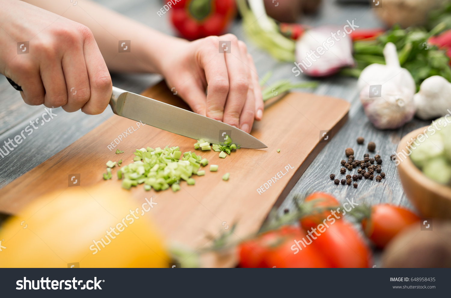 Chef cuts the vegetables into a meal. Preparing dishes. A woman uses a knife and cooks. #648958435