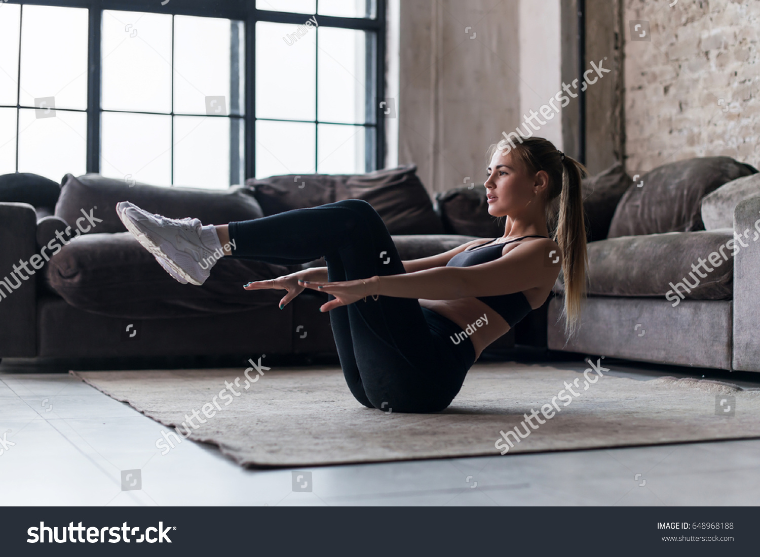Slim sporty girl doing v-ups abs workout at home #648968188