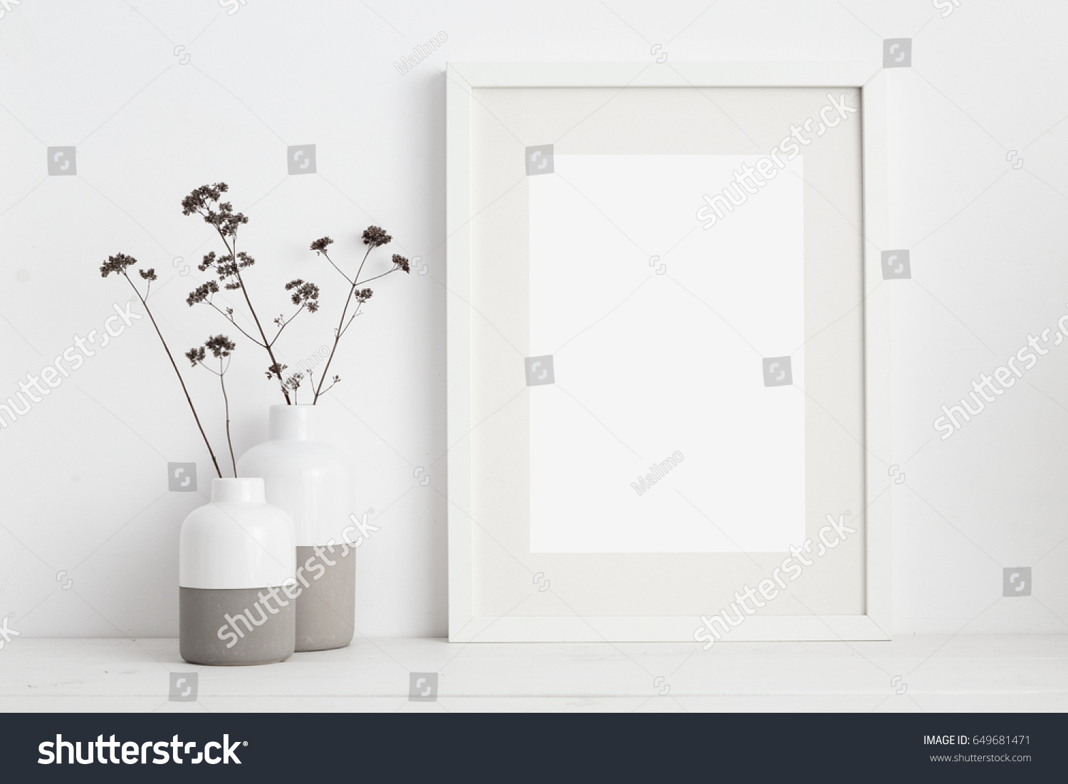 Mock up white frame and dry twigs in vase on book shelf or desk. White colors.
