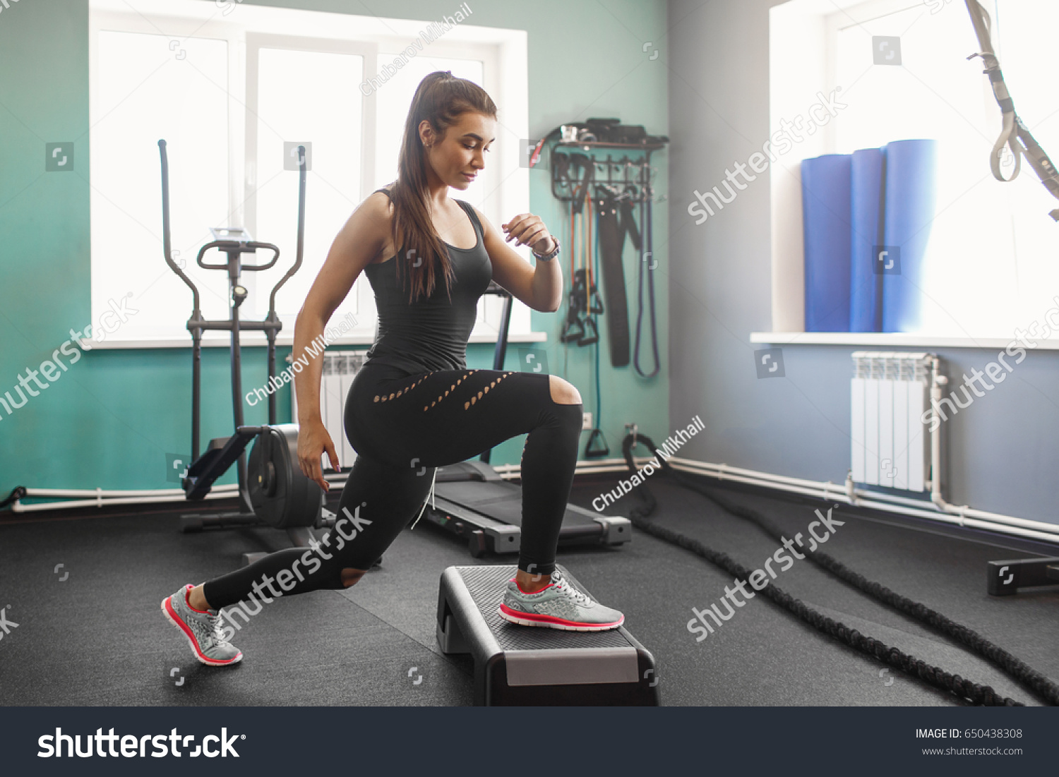 young fitness woman in the gym. A young athlete trains in the gymnasium. Power training. A warm-up in the gym. #650438308