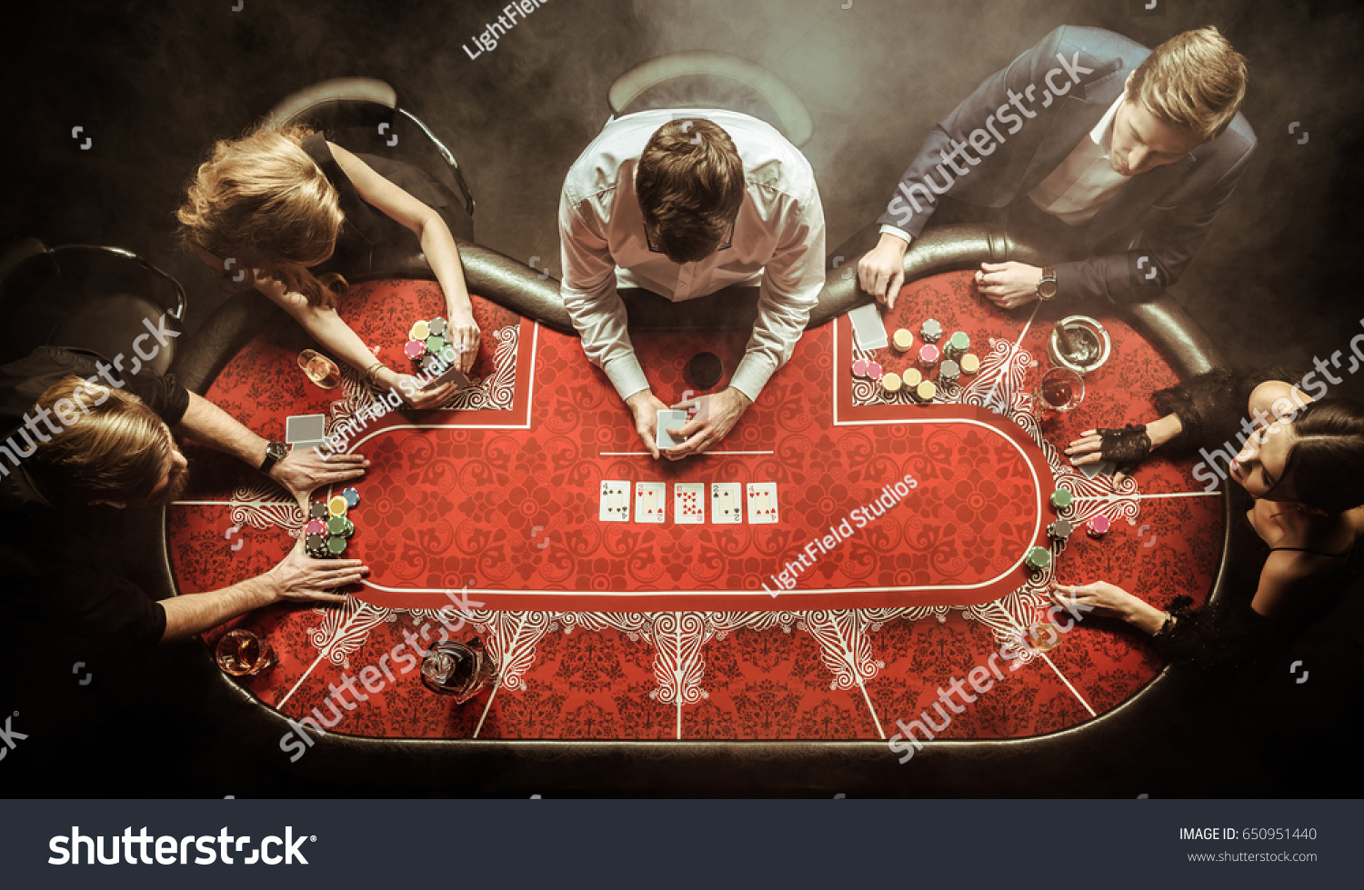 top view of men and women playing poker in casino #650951440