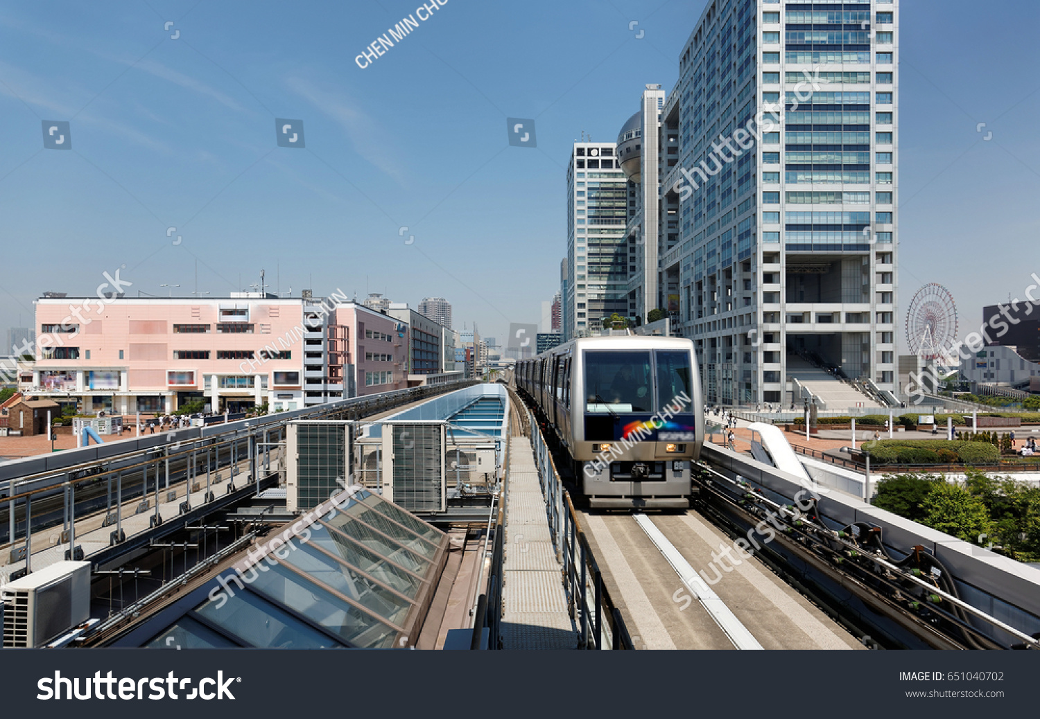 Scenery of a train traveling on the elevated rail of Yurikamome Line, passing by the famous landmark Fuji TV Building in Odaiba, Minato, Tokyo, under blue clear sunny sky (colorful painting version) #651040702