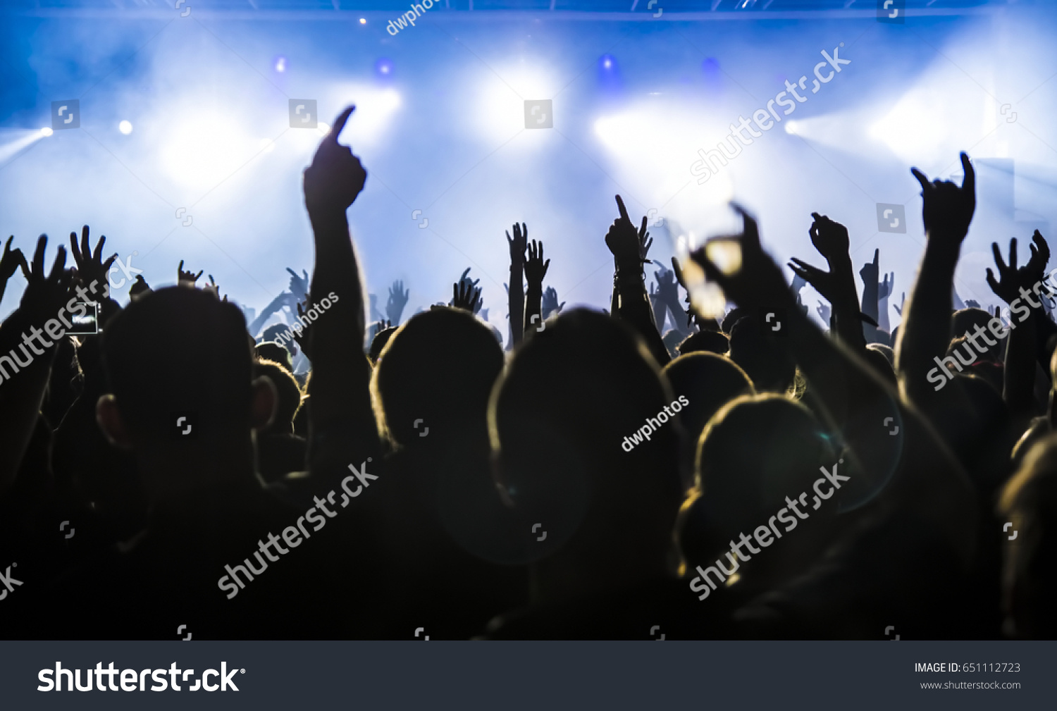 silhouettes of concert crowd in front of bright stage lights #651112723