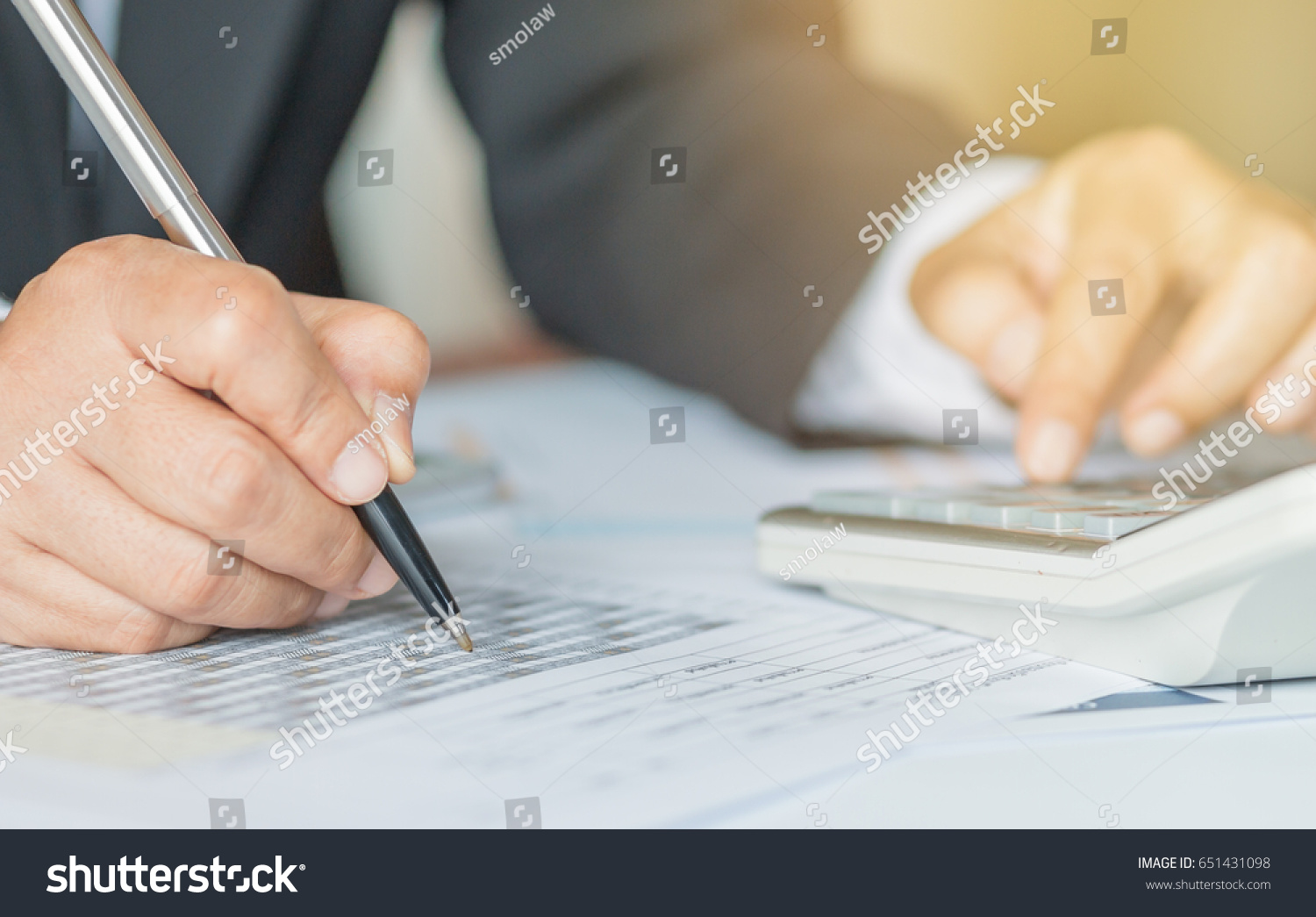 Hand calculator and holding pen for analyzing financial data and counting on document chart, business concept. #651431098