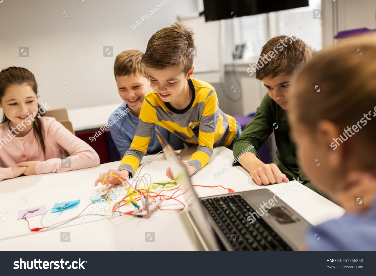 education, children, technology, science and people concept - group of happy kids with laptop computer playing and invention kit at robotics school lesson #651766858