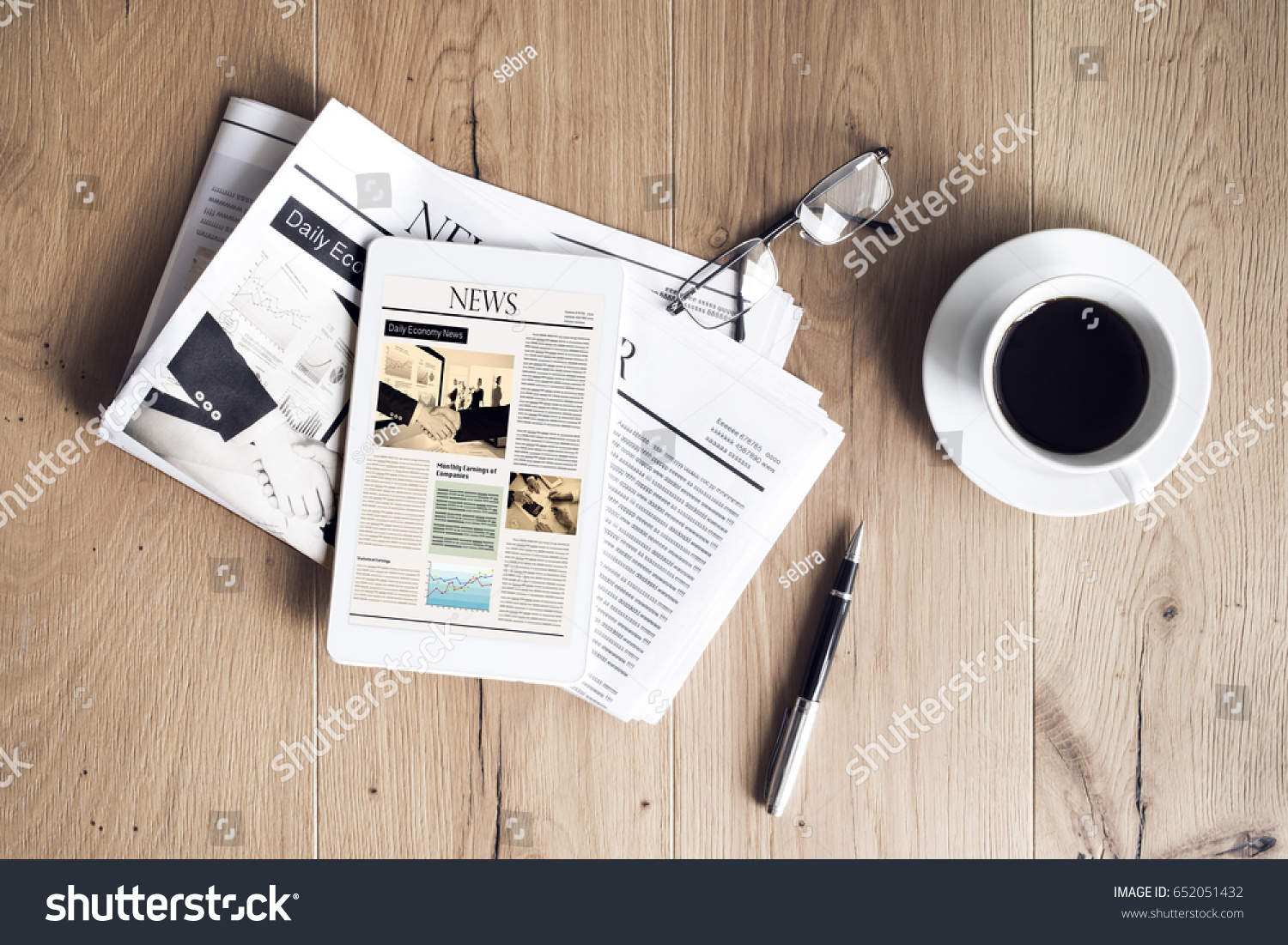 Newspaper with tablet on wooden table #652051432