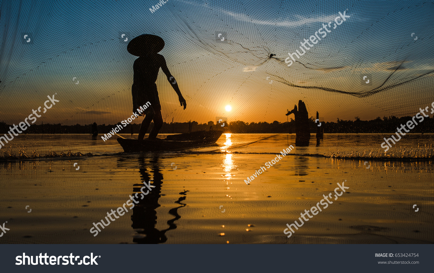 Silhouette Fisherman Fishing Nets on the boat.Thailand #653424754