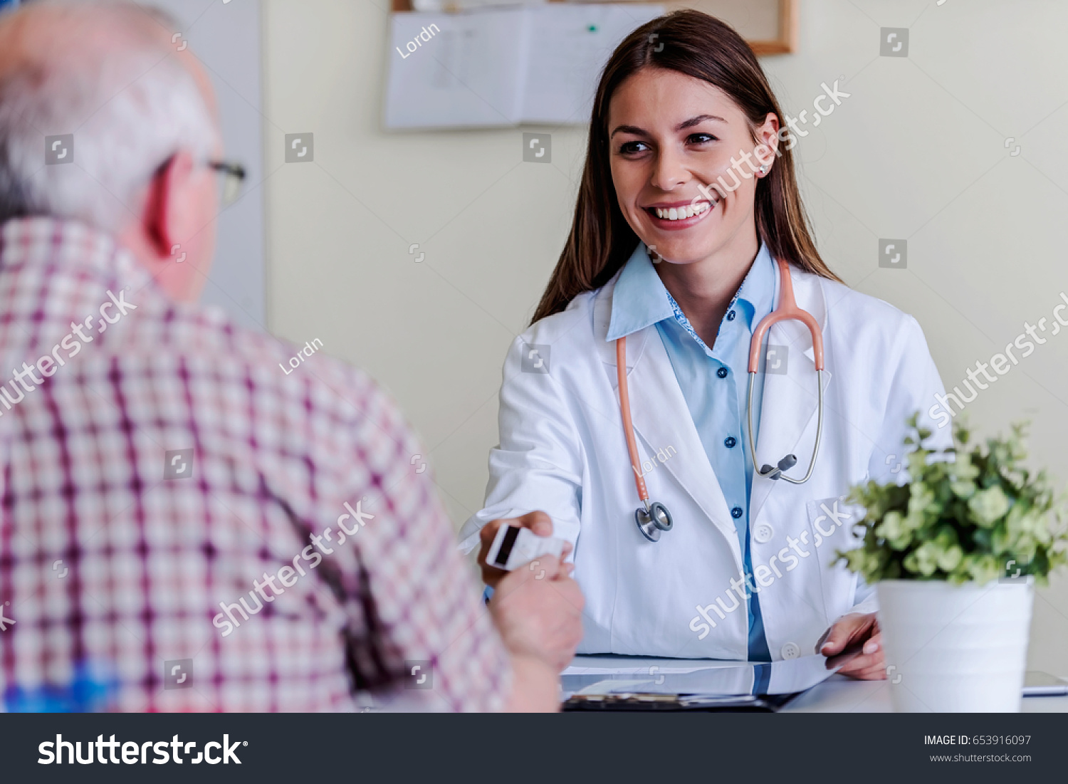 Older patient at woman doctor office paying exam with credit card #653916097