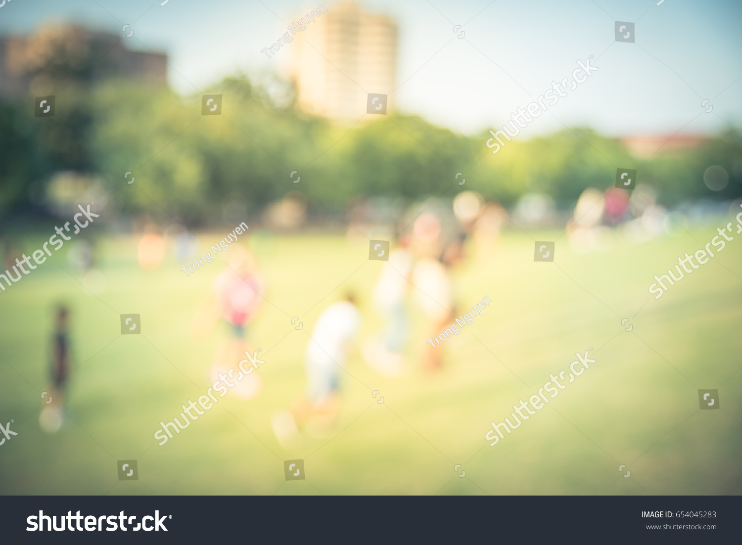 Blurred kids running, chasing each other on grass hill at sunset in summertime. Group smiling African American child running across hill urban park at Houston, Texas. Light, happy scene, vintage tone. #654045283