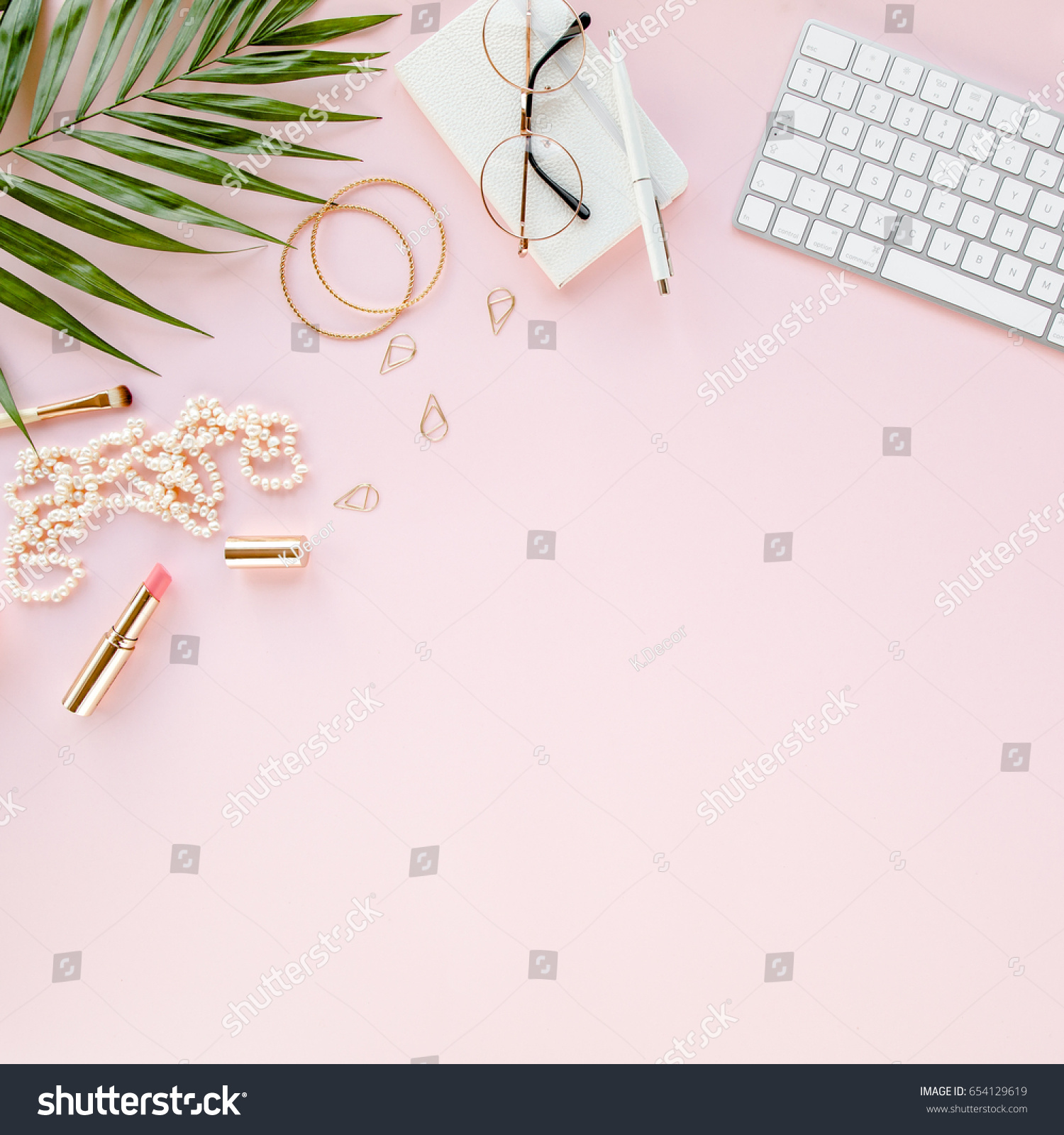 Office table desk with computer,  green leaves palm, clipboard. Magazines, social media. Top view. Flat lay. Home office workspace. Women's fashion accessories isolated on pink background.  #654129619