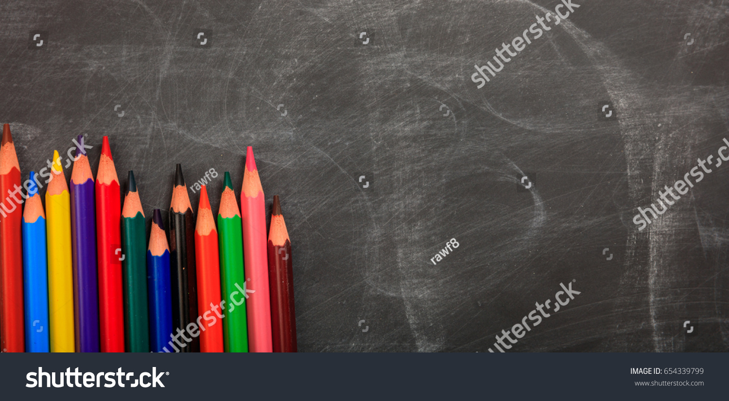 Colored pencils on a black chalkboard - space for caption #654339799