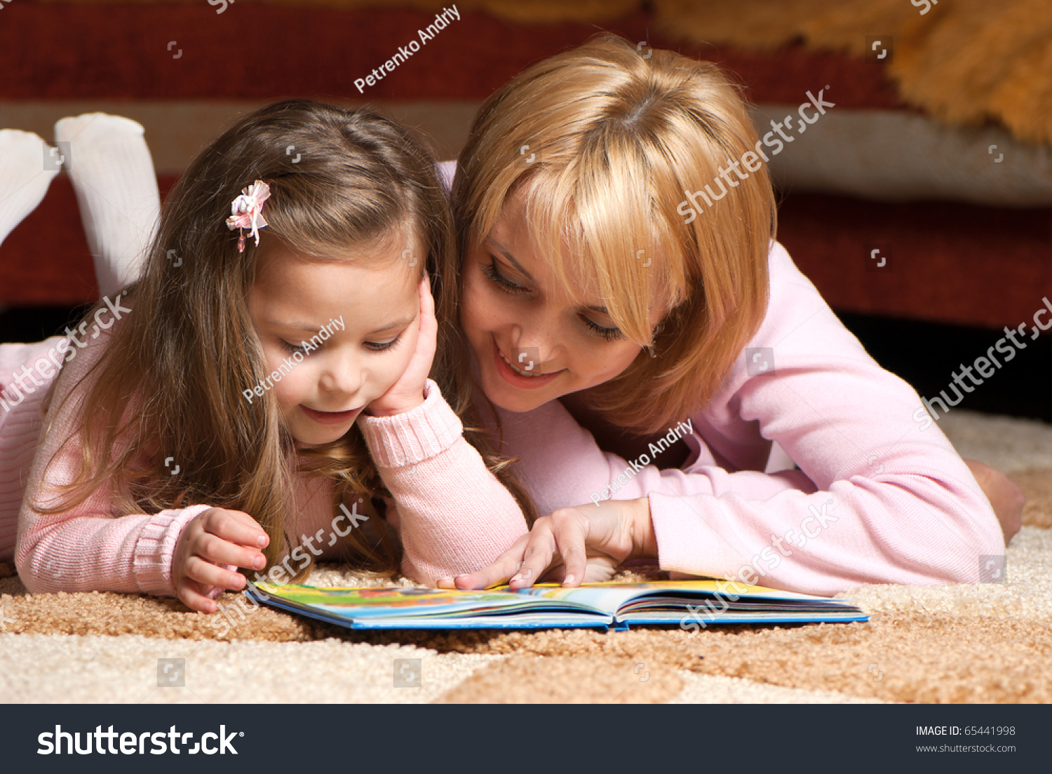 sweet  little girl with mother reading book #65441998