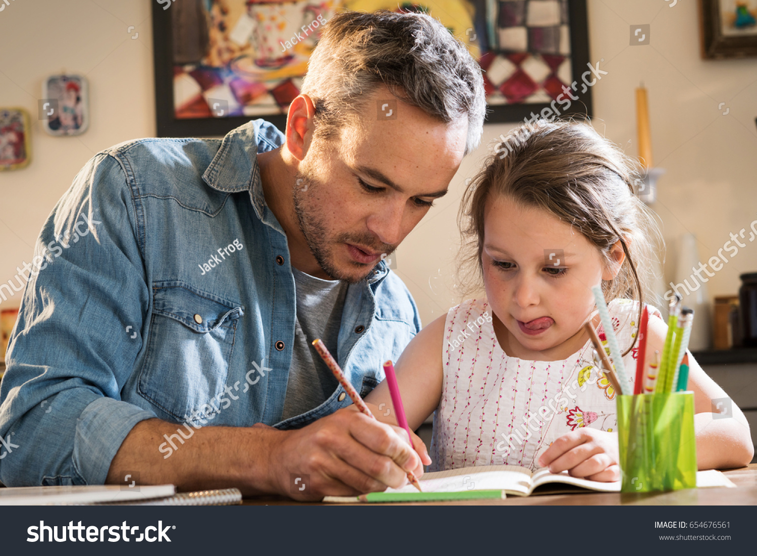 A father helps his little daughter to do her homework for the school. #654676561