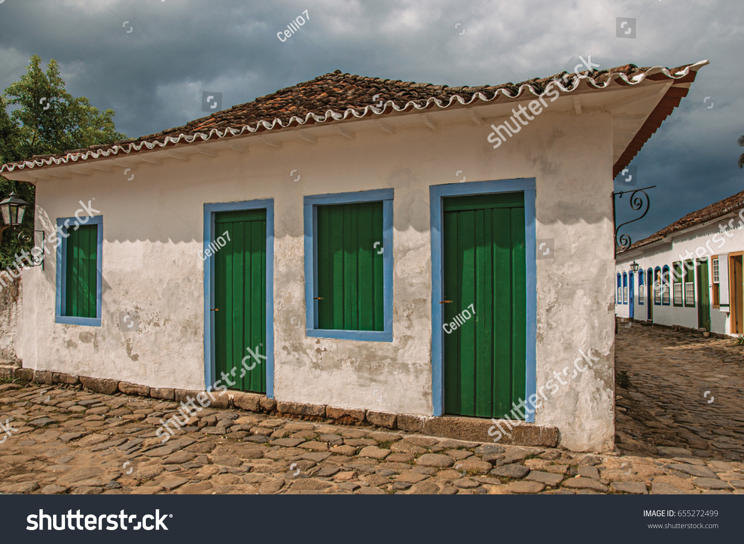 Overview of old house and alleyway with cobblestone on cloudy day in Paraty, an amazing and historic town totally preserved in the coast of the Rio de Janeiro State, southwestern Brazil #655272499