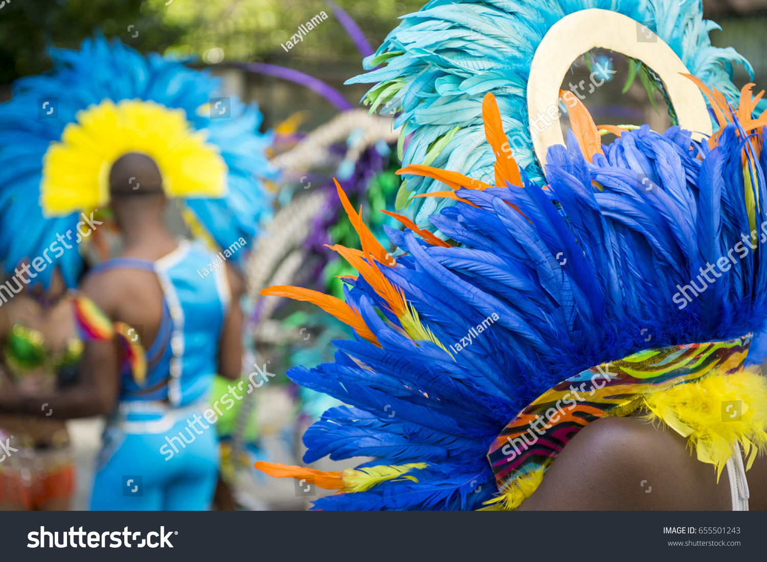 Group of dancers wearing colorful feathers costumes gathered for a gay pride street parade #655501243