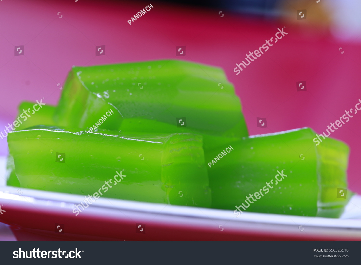 green layer sweet cakes on white dish and red background #656326510