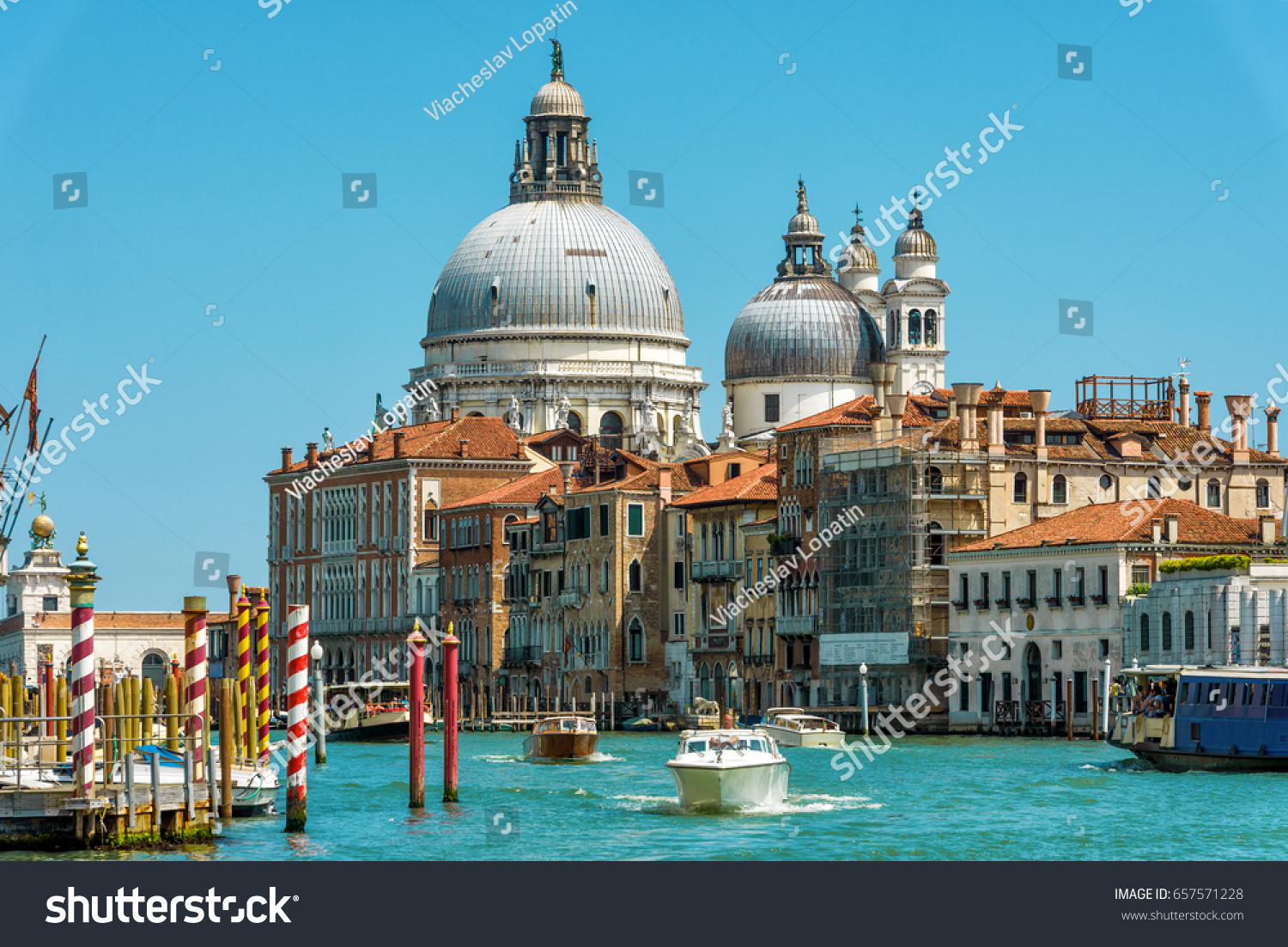 Water taxis and other tourist boats sail on the Grand Canal, Venice, Italy. Motor boats are the main transport in Venice. Nice panorama of Venice in summer. Romantic marine trip across sunny Venice. #657571228