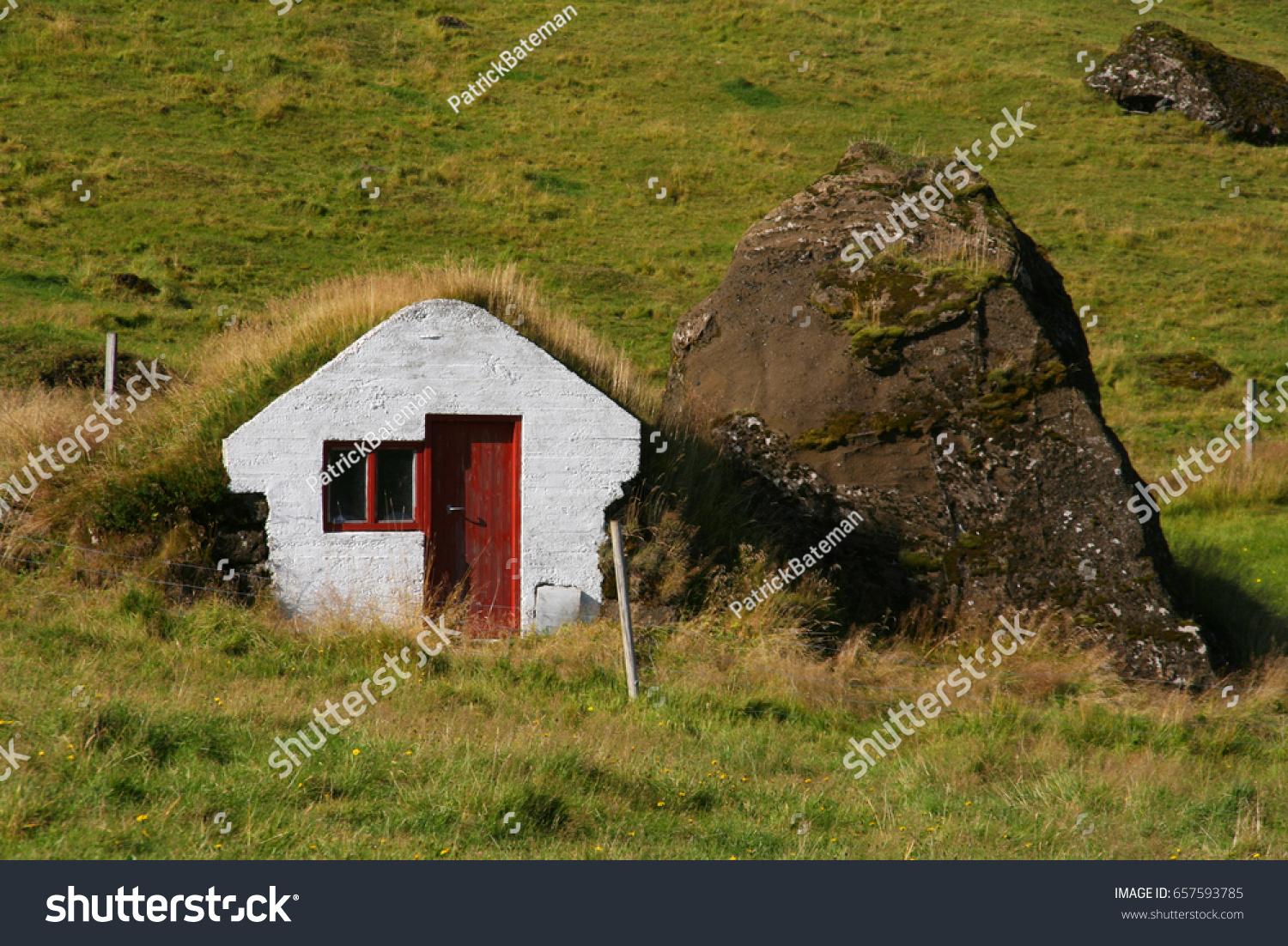 Little white elf house with turf roof and a mossy stone in Iceland #657593785