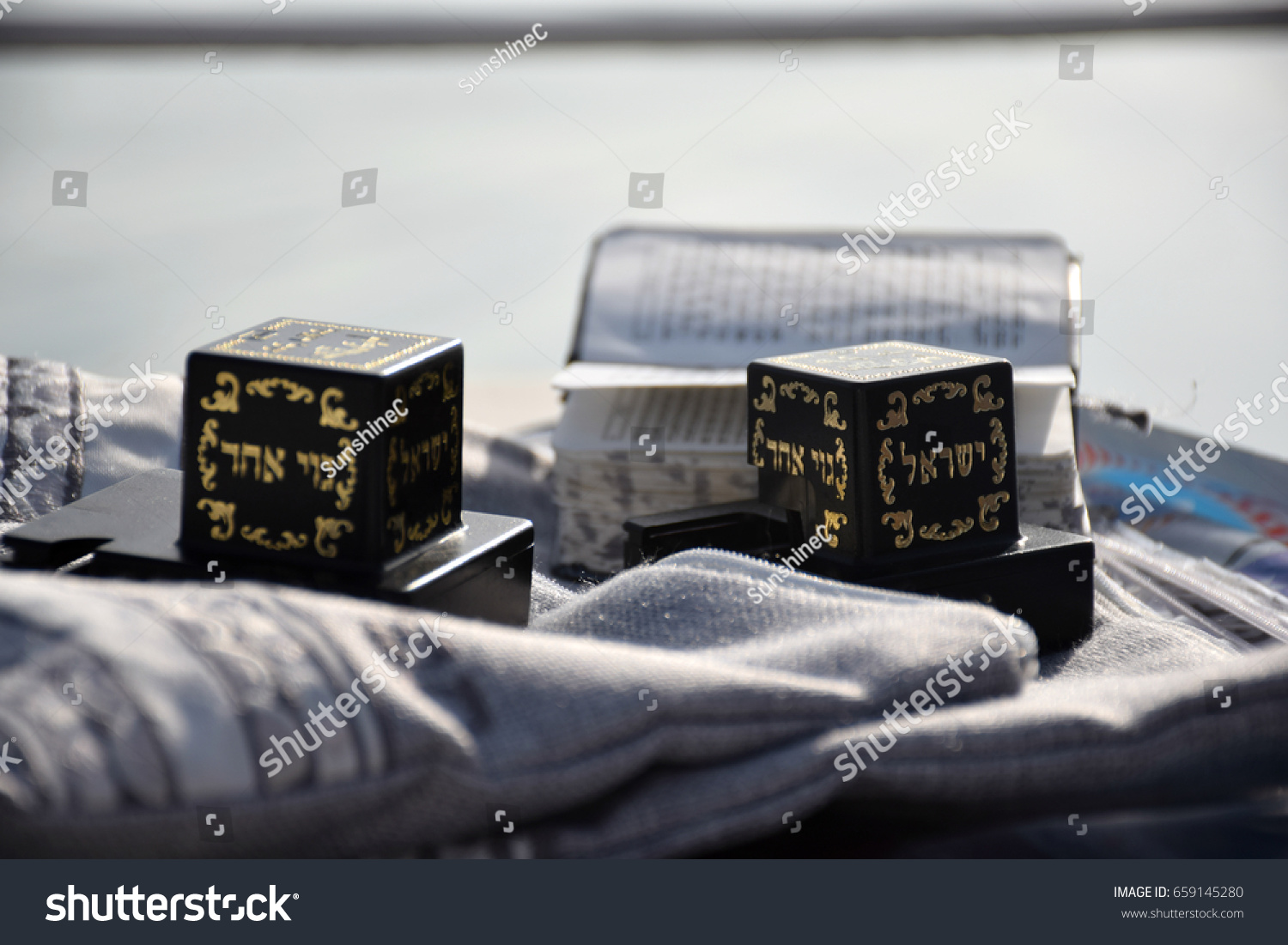 Tefillin (Judaica item using for the famous jewish prayer "Shema Israel" - hear us our lord) and the Jewish bible on a Shawl bag. #659145280