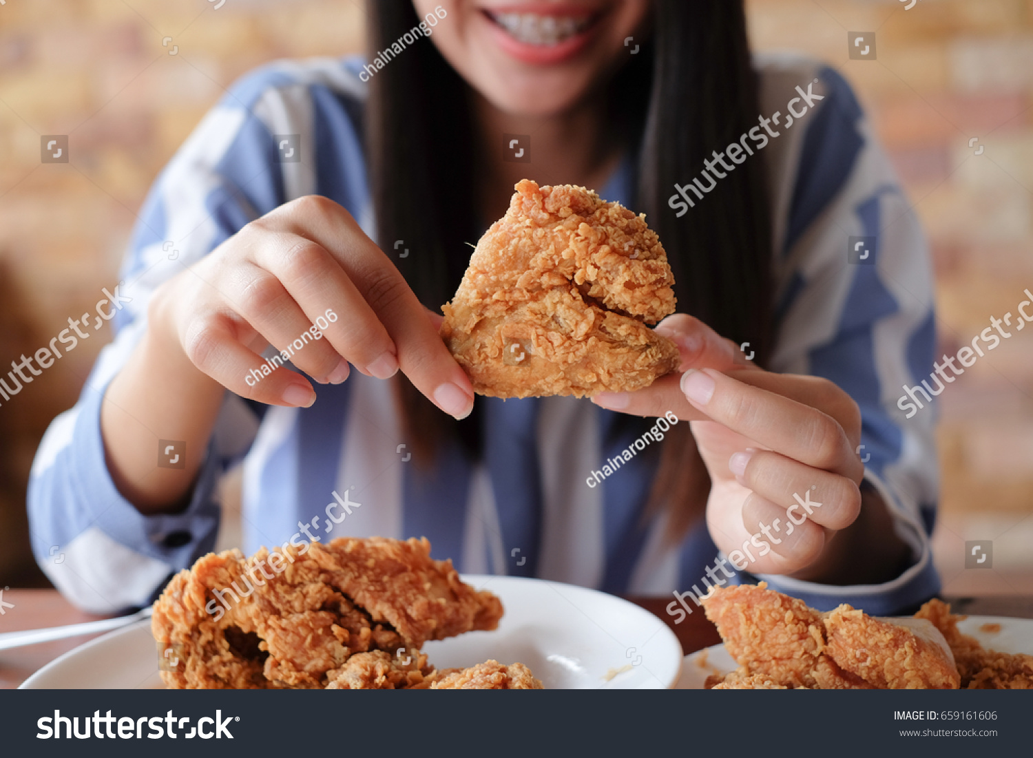 close up focus woman hand hold fried chicken for eat,girl with fast food concept #659161606