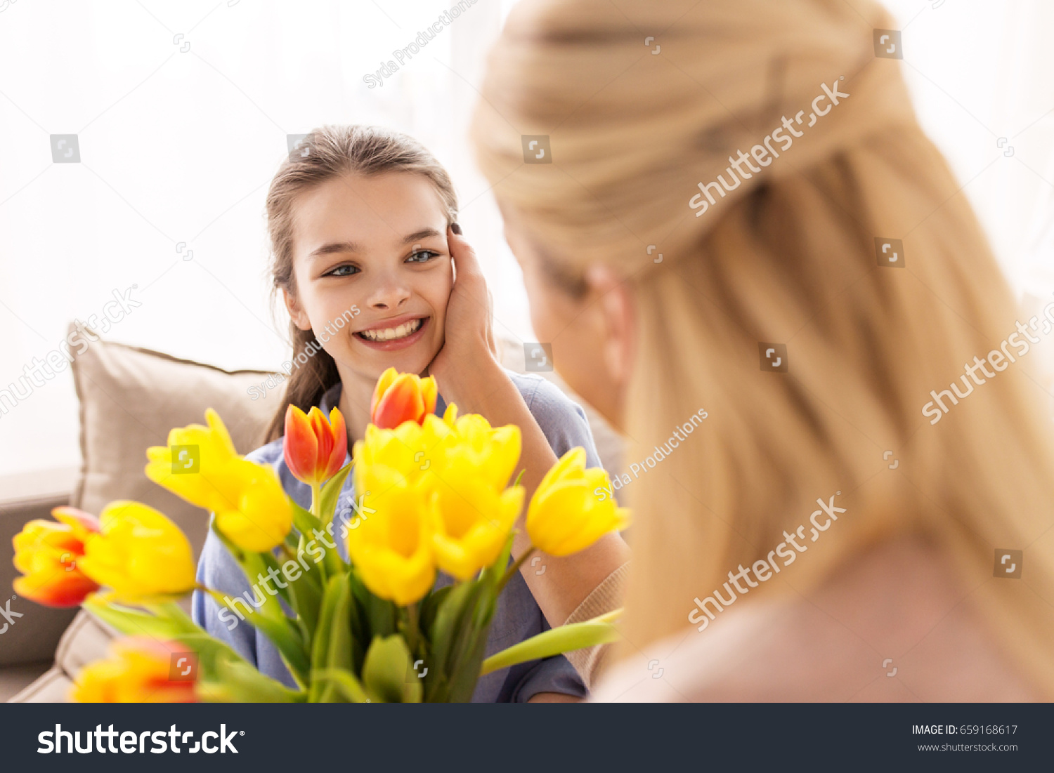 people, family and holidays concept - happy girl giving tulip flowers to her mother at home #659168617