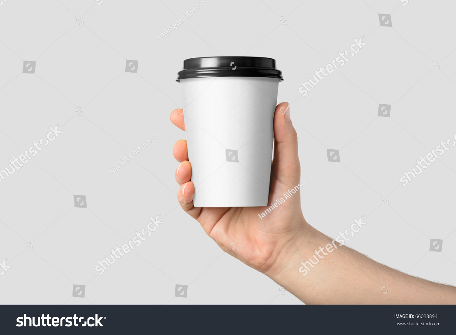 Mockup of male hand holding a Coffee paper cup isolated on light grey background.  #660338941