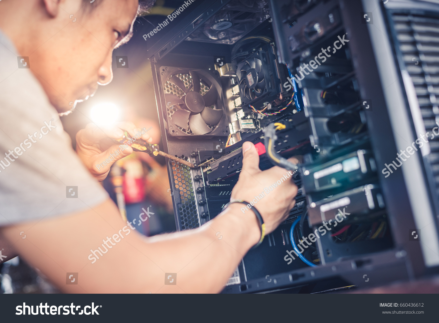 The technician hold the screwdriver for repairing the computer. the concept of computer hardware, repairing, upgrade and technology. #660436612
