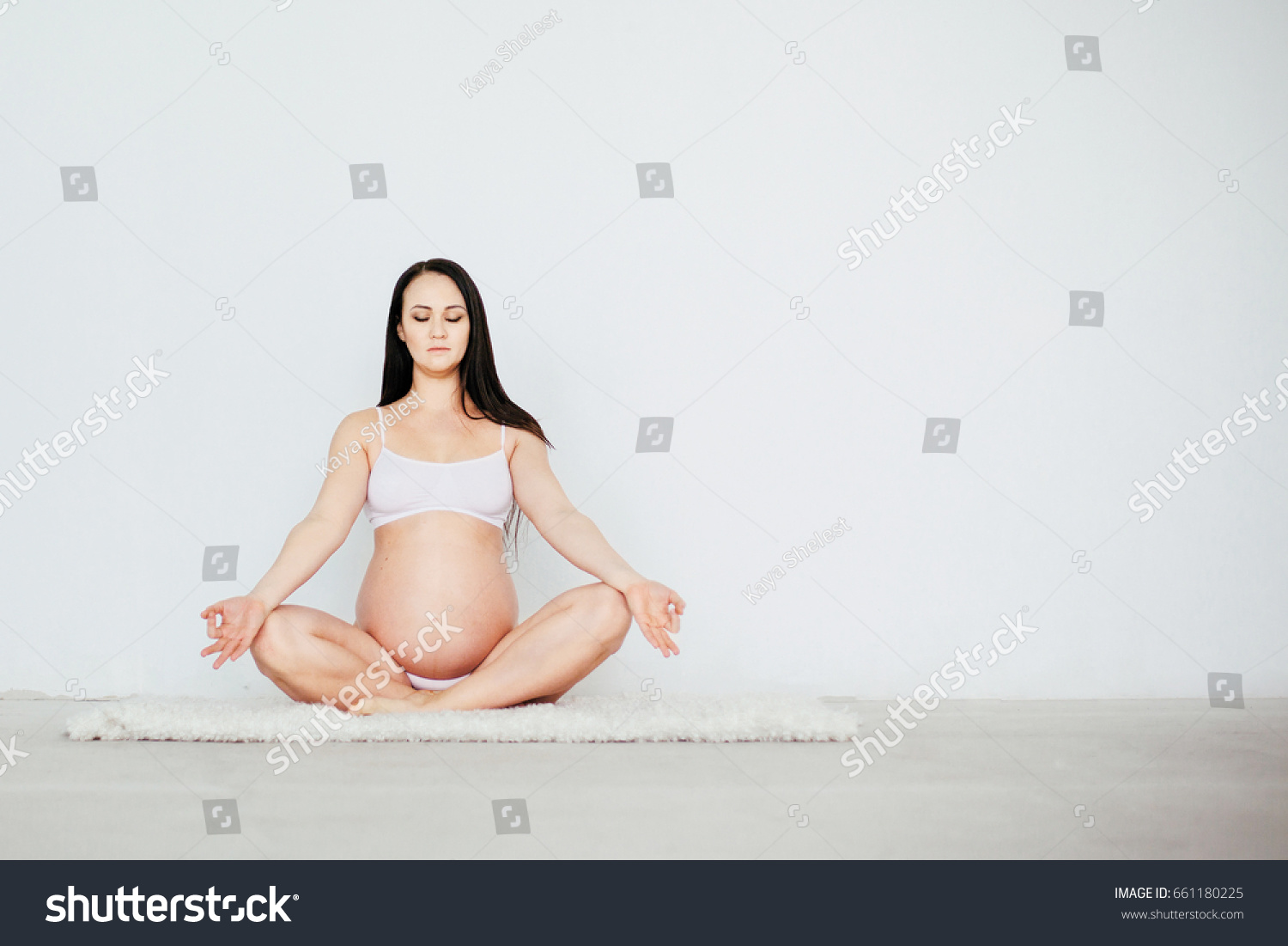 Beautiful pregnant woman doing prenatal yoga exercises - lotos pose, healthy  lifestyle concept #661180225