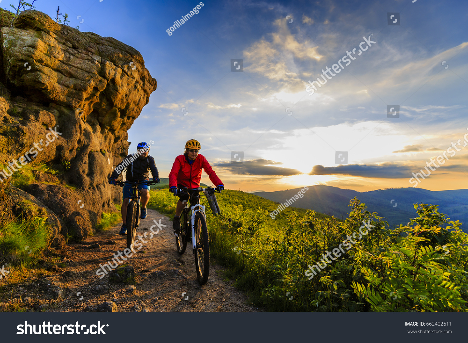 Mountain biking women and man riding on bikes at sunset mountains forest landscape. Couple cycling MTB enduro flow trail track. Outdoor sport activity. #662402611