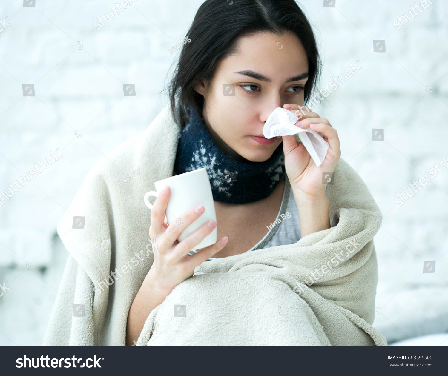 Young woman sick in bed with temperature drinks hot. Indoor shot. #663596500