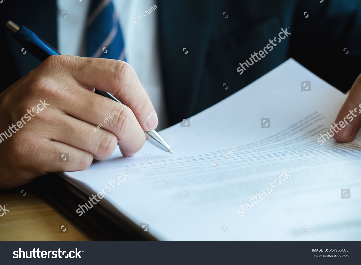 Close up business man reaching out sheet with contract agreement proposing to sign.Full and accurate details, individual who owns the business sign personally,director of the company, solicitor. #664956685