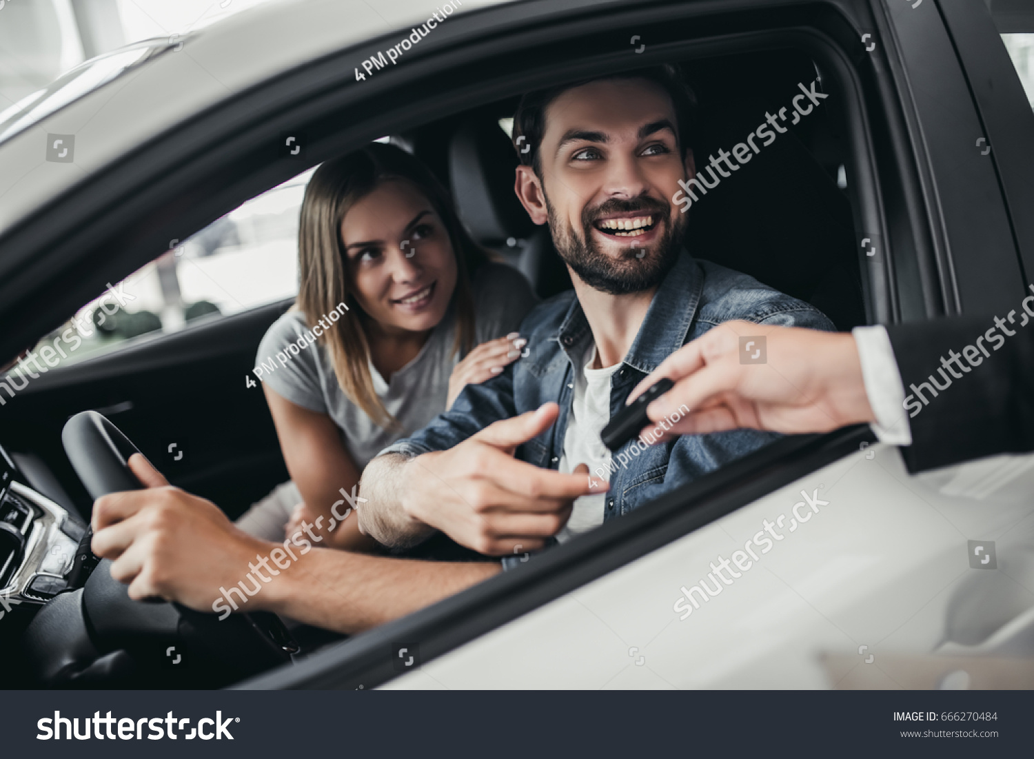 Happy beautiful couple is choosing a new car at dealership. #666270484