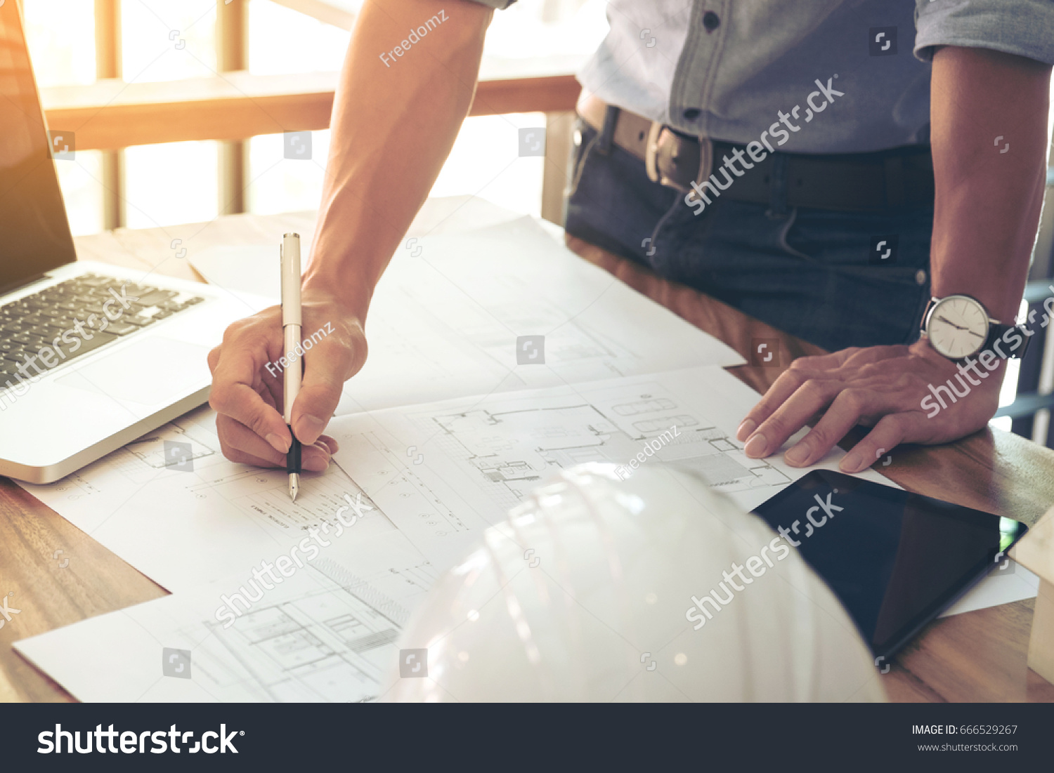 Image of engineer or architectural project, Close up of engineer's hand drawing plan on BluePrint with Engineering tools on workplace. #666529267