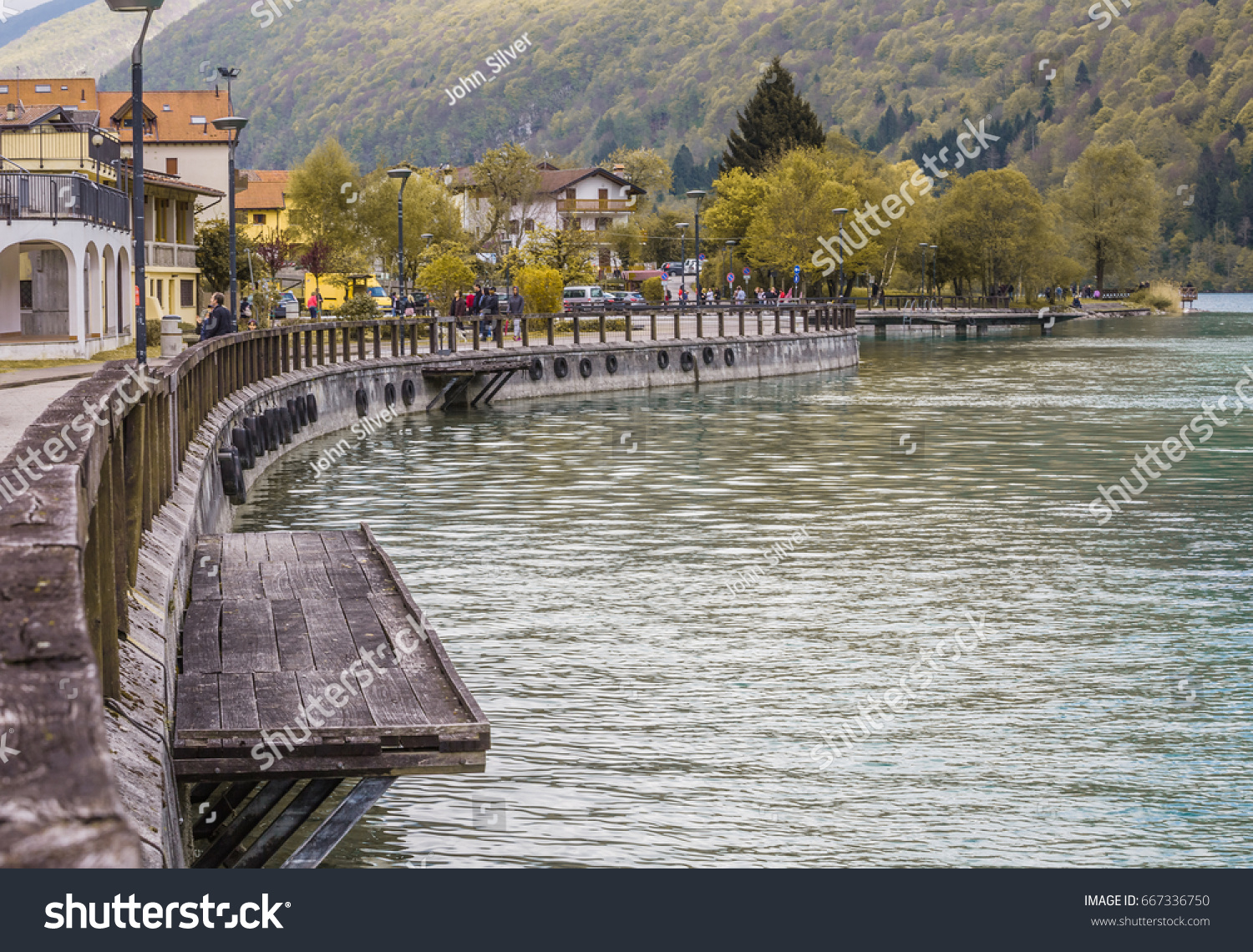 view of the Barcis city on the lakeside surrounding mountains against a dramatic cloudy blue sky background in Valcellina, Pordenone, Italy
 #667336750
