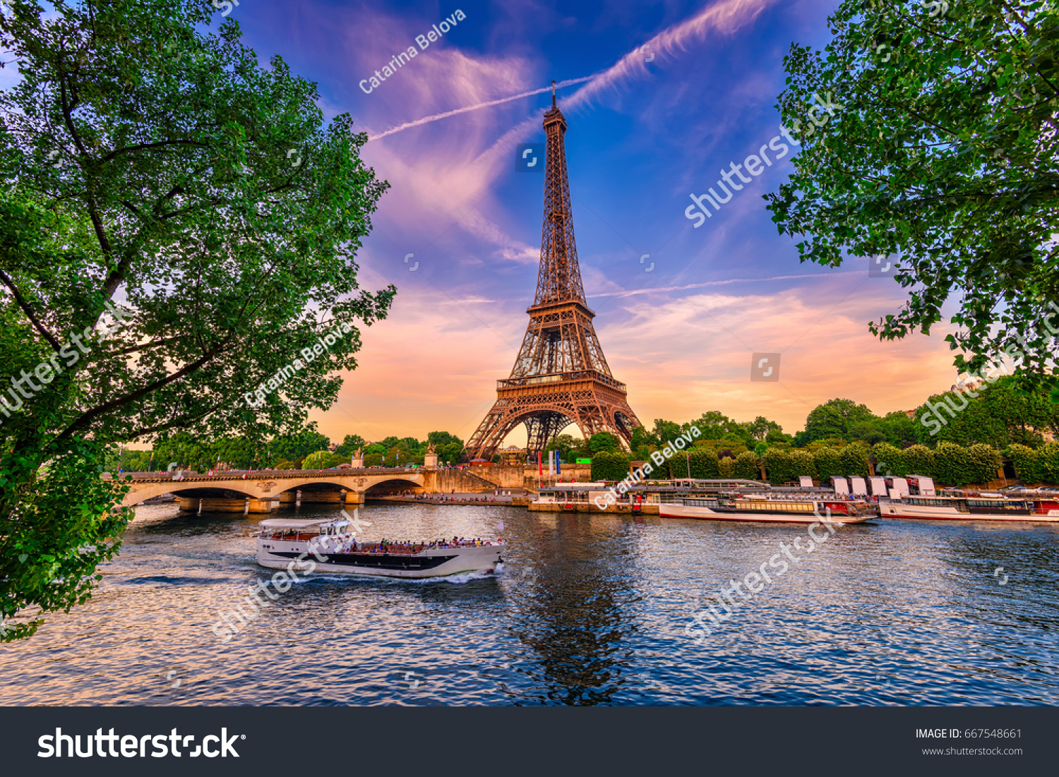 Paris Eiffel Tower and river Seine at sunset in Paris, France. Eiffel Tower is one of the most iconic landmarks of Paris. #667548661
