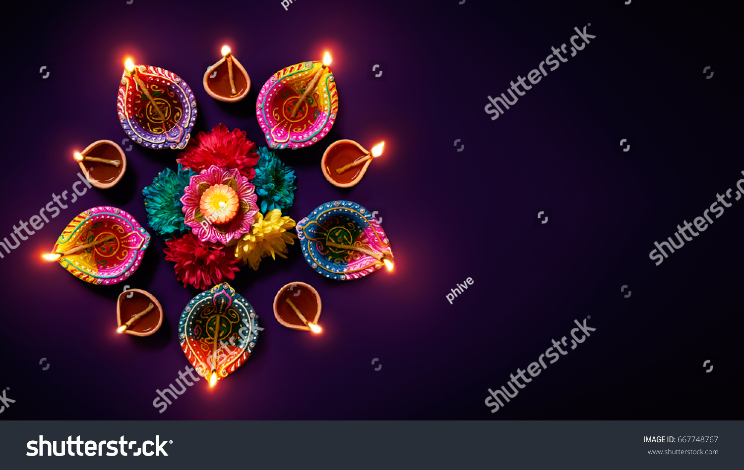 Colorful clay diya lamps with flowers on purple background #667748767