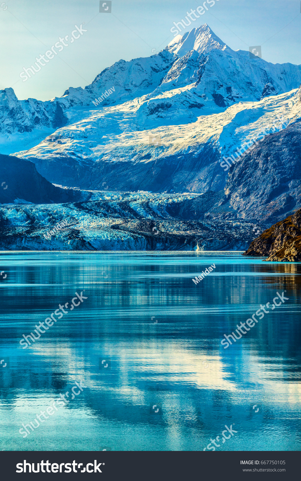 Glacier Bay Alaska cruise vacation travel. Global warming and climate change concept with melting ice. Cruising boat towards landscape of Johns Hopkins Glacier and Mount Fairweather Range mountains. #667750105