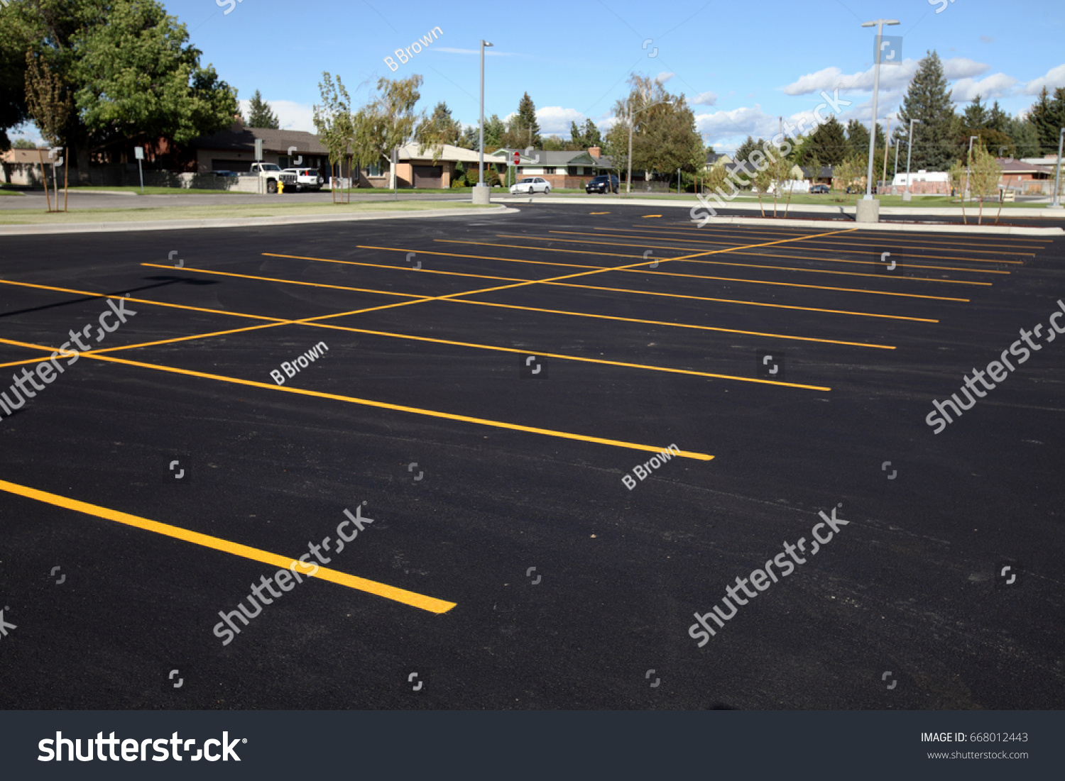 A newly completed parking lot with freshly painted yellow lines to mark the stalls. #668012443