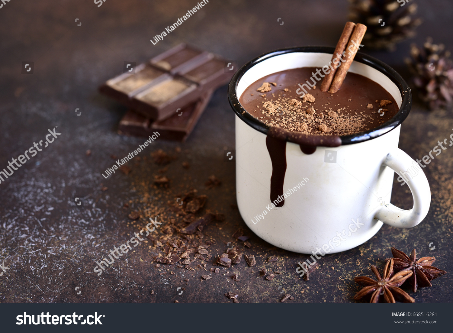 Homemade spicy hot chocolate with cinnamon in enamel mug on a slate,stone or concrete background. #668516281