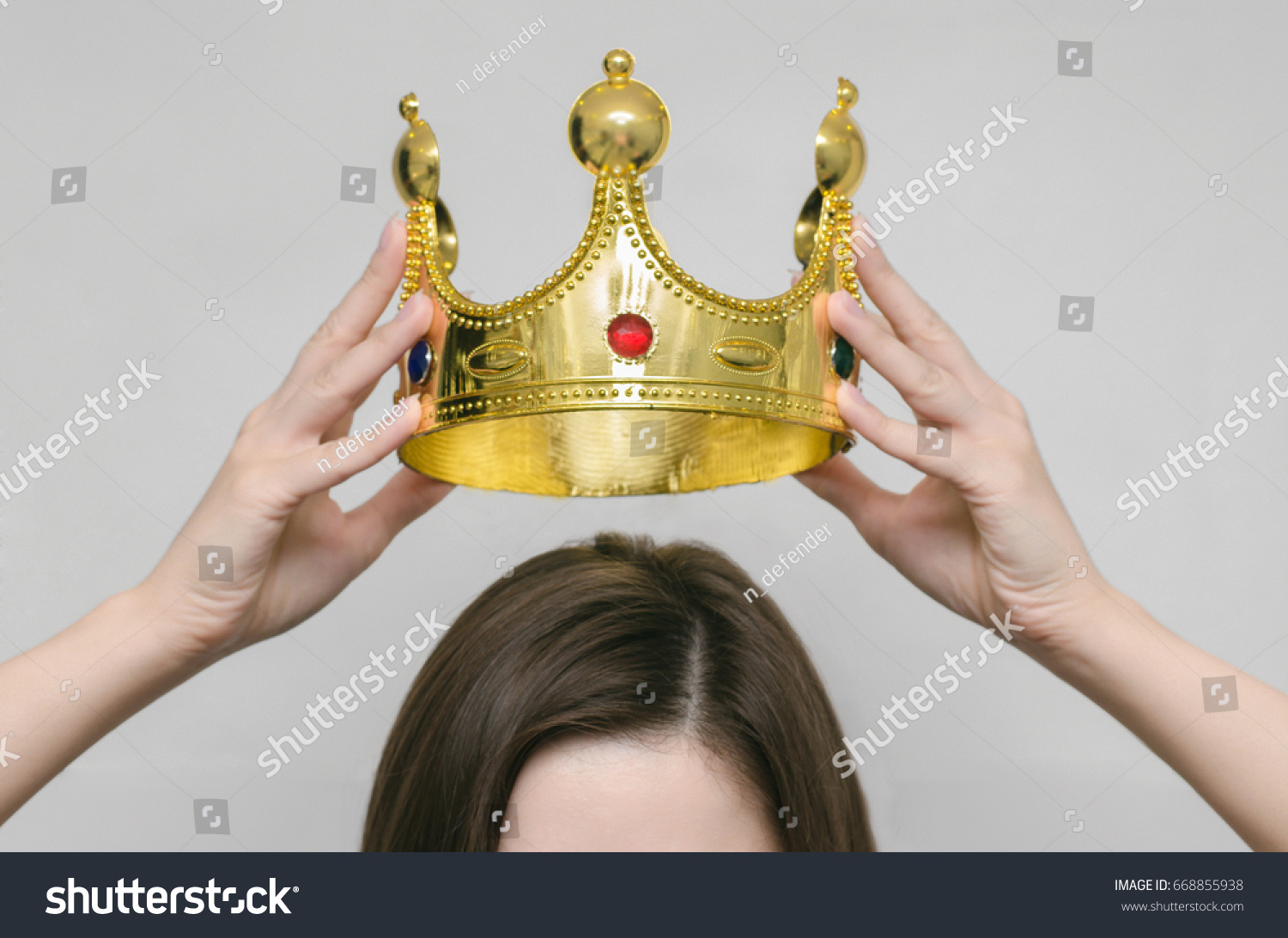 Woman girl holding above a head the golden crown. Leadership, success , queen. #668855938