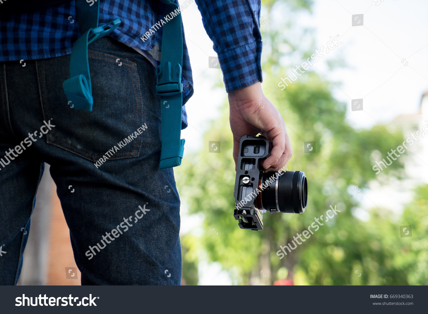 Photographer standing and holding camera  #669340363