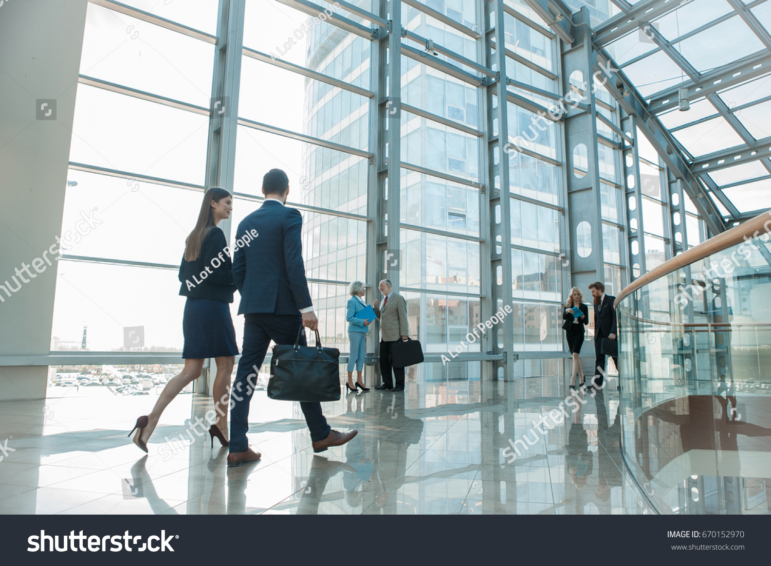 Business people walking in modern glass office building #670152970